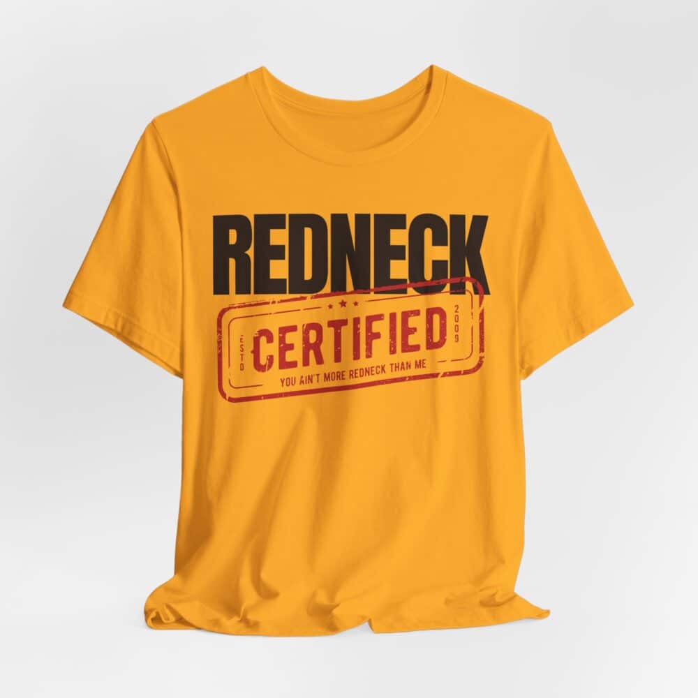 The Redneck Certified Tshirt is a yellow shirt featuring "REDNECK CERTIFIED" and "You ain't more redneck than me" printed on the front in bold black and red letters.