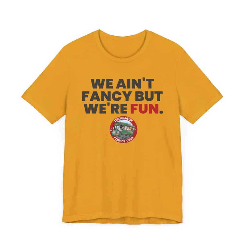 The We Ain't Fancy Tshirt is a yellow tee featuring "WE AIN'T FANCY BUT WE'RE FUN." and a circular badge below that reads "THE REDNECK COMEDY TOUR.