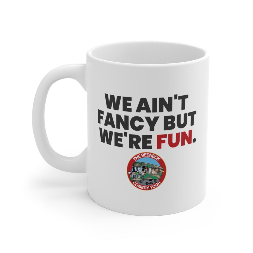 The We Ain't Fancy Coffee Mug - White features "WE AIN'T FANCY BUT WE'RE FUN." and The Redneck Comedy Tour logo with a cartoon bus at the bottom.