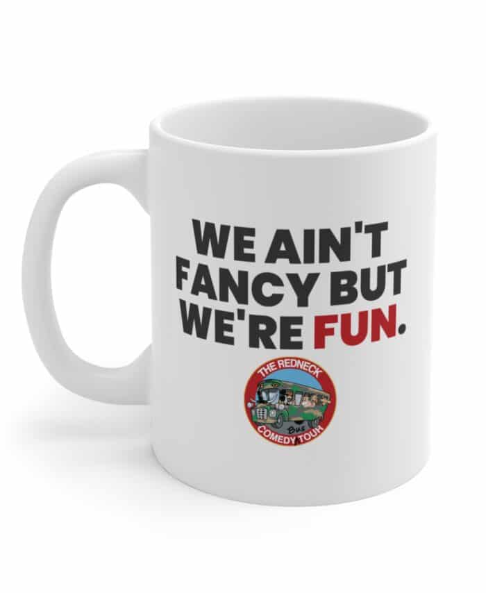 The We Ain't Fancy Coffee Mug - White features "WE AIN'T FANCY BUT WE'RE FUN." and The Redneck Comedy Tour logo with a cartoon bus at the bottom.