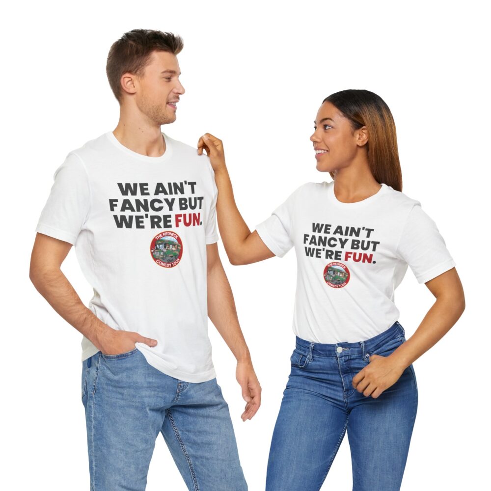 A smiling man and woman wear matching "We Ain't Fancy Tshirt" in white with jeans, facing each other. Their shirts say, "WE AIN'T FANCY BUT WE'RE FUN.