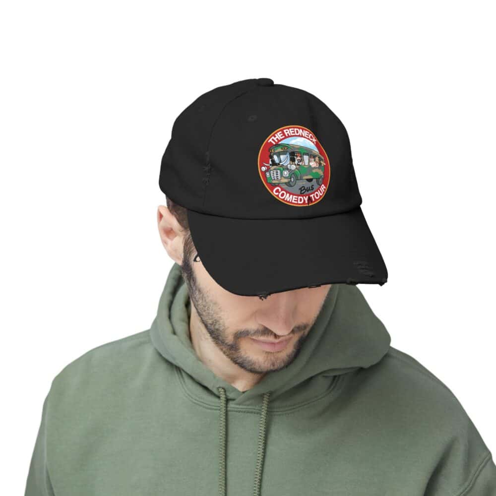 Man wearing a green hoodie and the Redneck Comedy Tour Distressed Hat, looking downward.