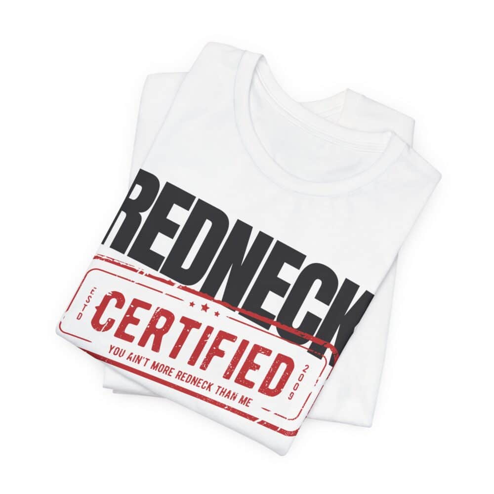 A folded Redneck Certified Tshirt in white features bold black "REDNECK" text and a red stamp-style graphic reading "CERTIFIED You ain't more redneck than me.