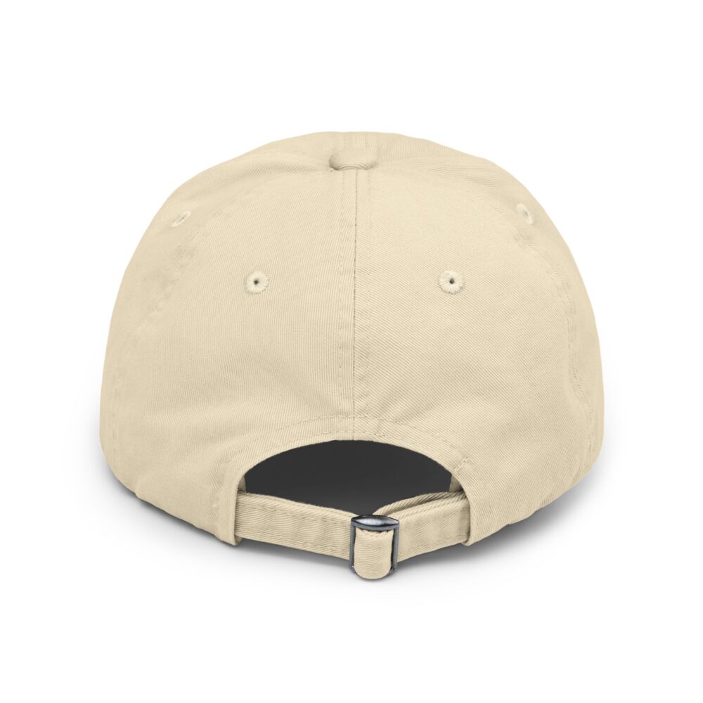 The Redneck Comedy Tour Distressed Hat is a beige baseball cap seen from the back, featuring ventilation eyelets and an adjustable strap with a metal buckle.