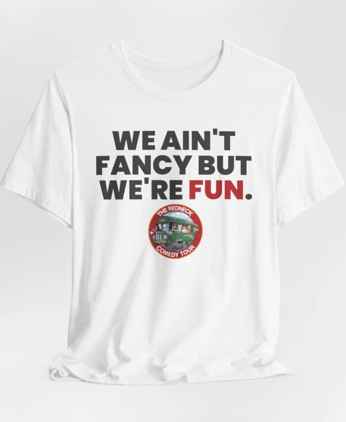 The "We Ain't Fancy Tshirt" is a white tee featuring bold text, "WE AIN'T FANCY BUT WE'RE FUN." above a circular The Redneck Comedy Tour logo.